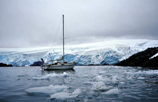 南極の氷の島とヨット、浮き氷に囲まれている。
